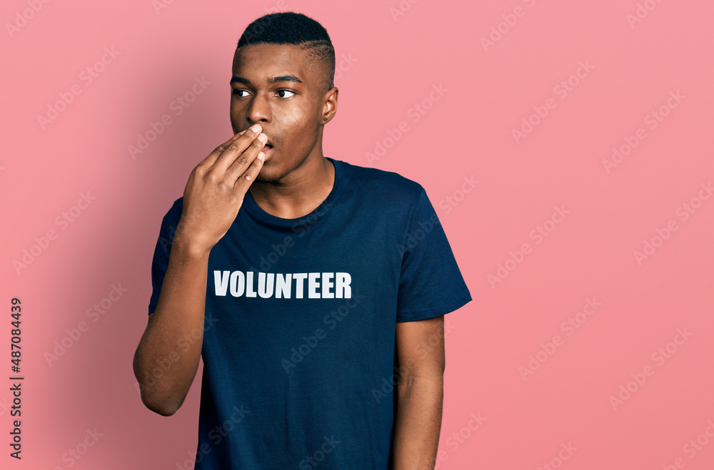 Young african american man wearing volunteer t shirt bored yawning tired covering mouth with hand. restless and sleepiness. Young african american man wearing volunteer t shirt bored yawning tired covering mouth with hand. restless and sleepiness.
