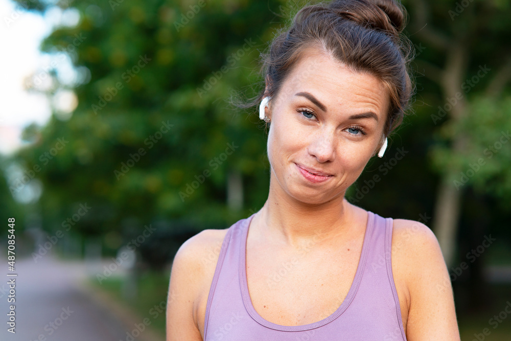 Close-up Portrait of a beautiful young, funny woman. Funny girl with emotions, listens to music in bluetooth wireless headphones. Close-up Portrait of a beautiful young, funny woman. Funny girl with emotions, listens to music in bluetooth wireless headphones.