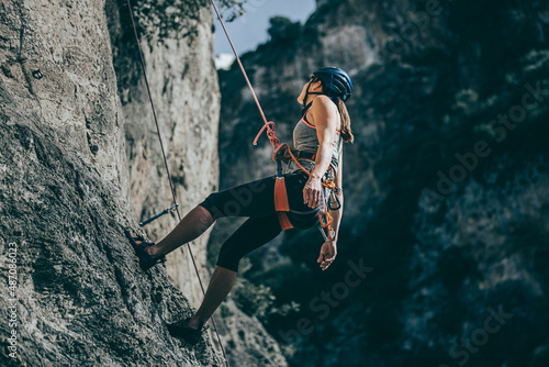 Fotografering Woman descending a cliff after a hard climb route