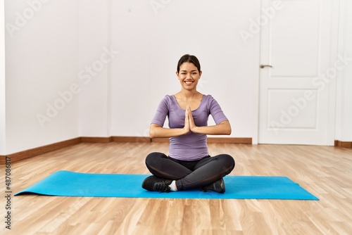 Young latin woman smiling confident training yoga at sport center
