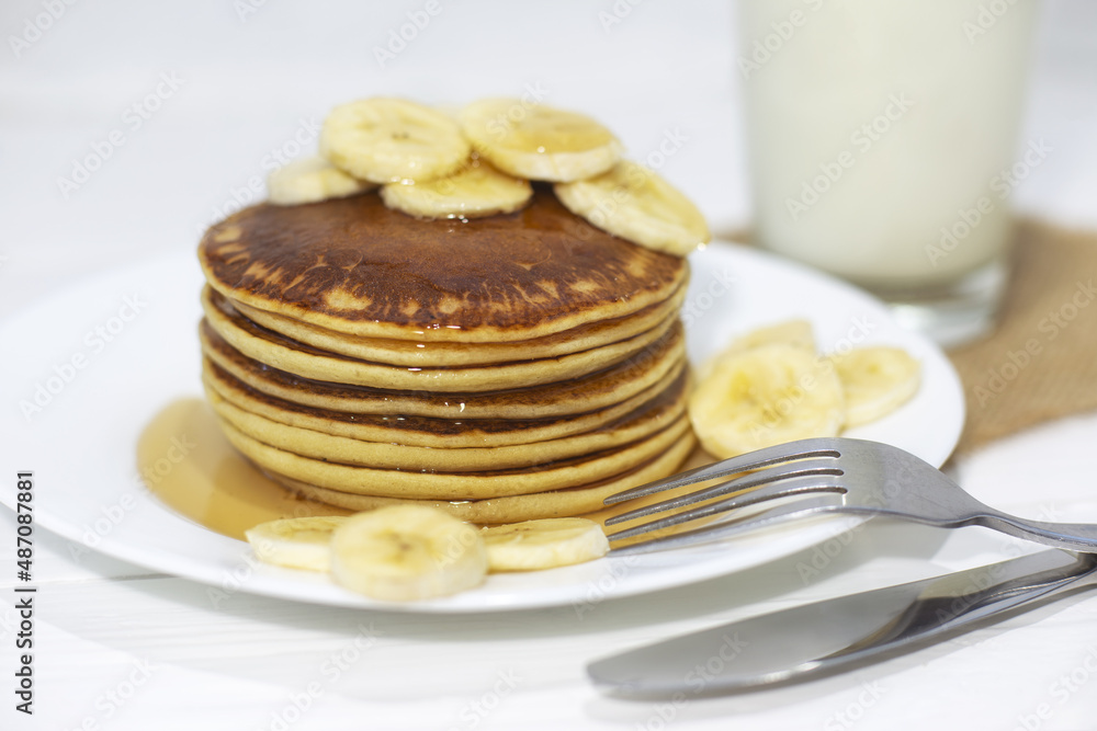 Pancakes with maple syrup and bananas.