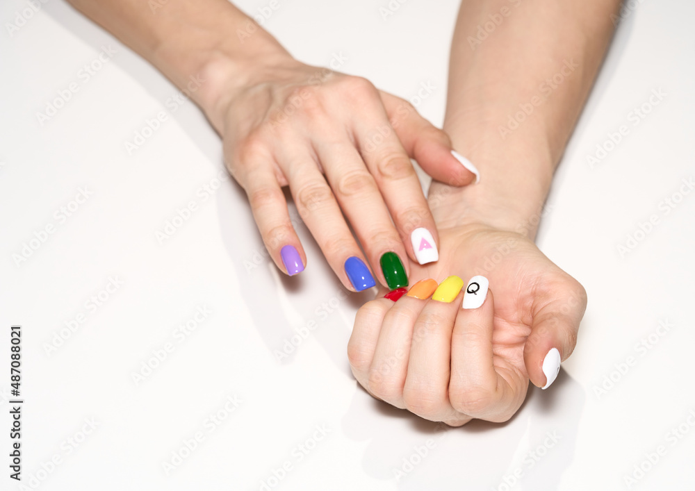 Hands with LGBT rainbow flag and rose triangle manicure. Symbol of lesbian, gay, bisexual, transgender and queer pride isolated on white background. 