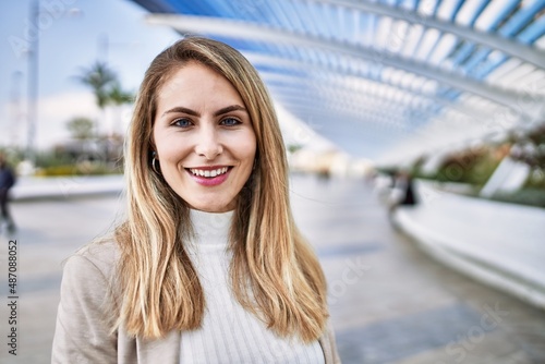 Young blonde woman smiling confident at street