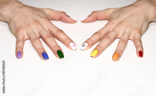 Hands making heart shape with LGBT rainbow flag and rose triangle manicure. Symbol of lesbian  gay  bisexual  transgender and queer pride isolated on white background. 