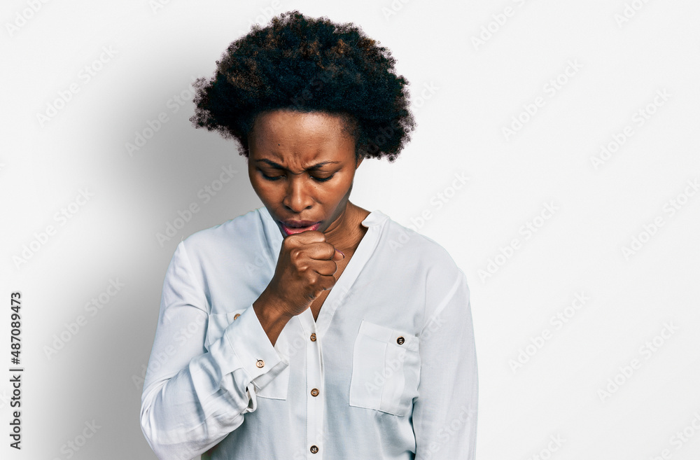 African american woman with afro hair wearing casual white t shirt feeling unwell and coughing as symptom for cold or bronchitis. health care concept. African american woman with afro hair wearing casual white t shirt feeling unwell and coughing as symptom for cold or bronchitis. health care concept.