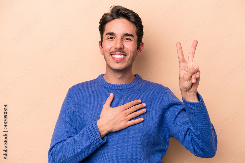 Young caucasian man isolated on beige background taking an oath, putting hand on chest. Young caucasian man isolated on beige background taking an oath, putting hand on chest.