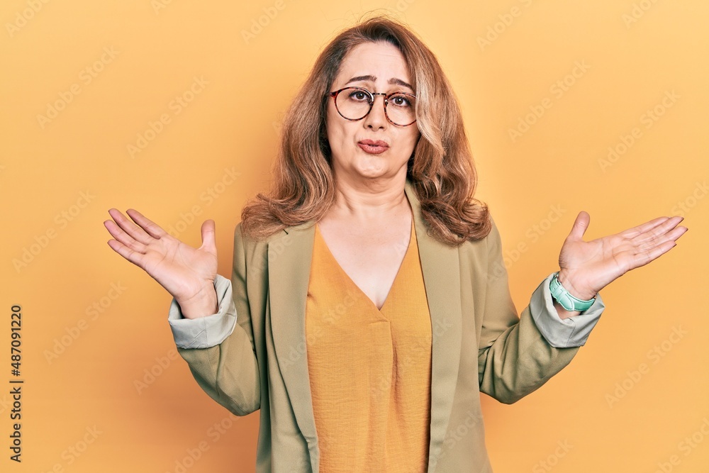 Obraz premium Middle age caucasian woman wearing casual clothes clueless and confused expression with arms and hands raised. doubt concept.