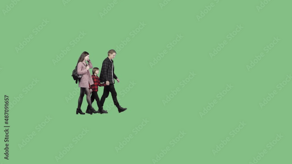 A young family with a little boy is walking on a green screen background. Isolated on transparent background A young family with a little boy is walking on a green screen background. Isolated on transparent background