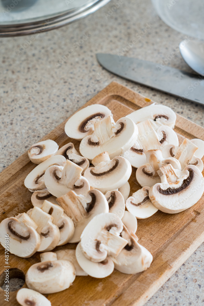 sliced mushrooms on a wooden board. Chopped champignons sliced mushrooms on a wooden board. Chopped champignons