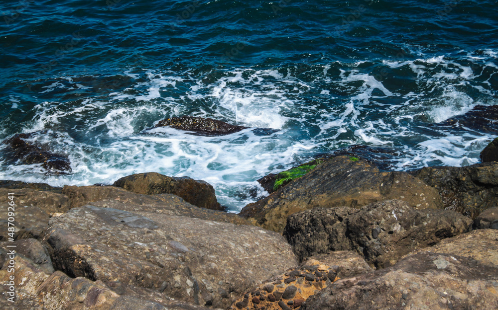 Fototapeta premium Waves on the beach, sea foam, rocky area.