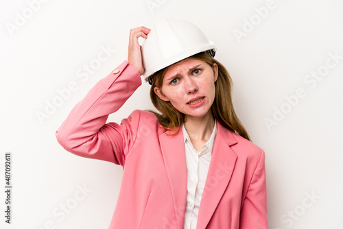 Young architect English woman with helmet isolated on white background being shocked, she has remembered important meeting.
