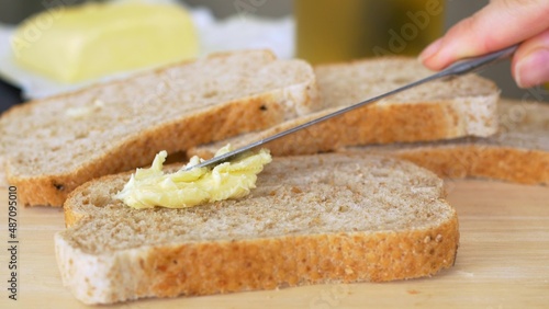 Spreading Vegan Butter On Rye Bread Without Dairy And Eggs. Closeup shot of a knife spreading butter on a piece of bread, tasty food being prepared for breakfast or lunch