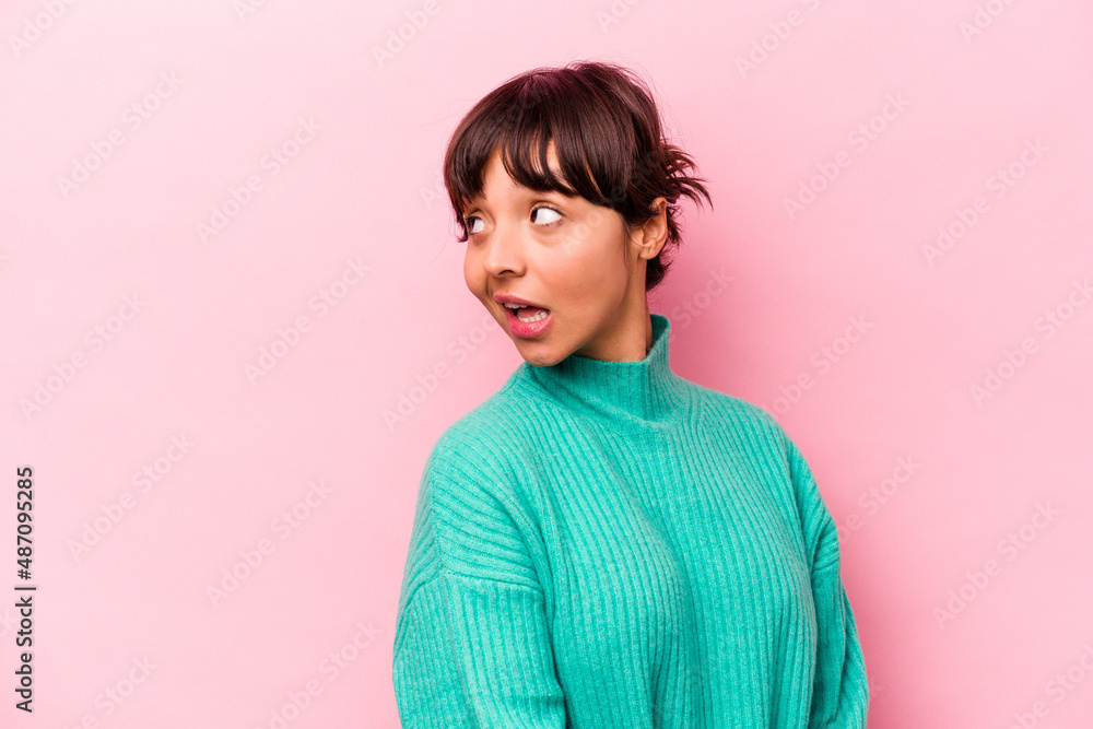 Young hispanic woman isolated on pink background looks aside smiling, cheerful and pleasant. Young hispanic woman isolated on pink background looks aside smiling, cheerful and pleasant.