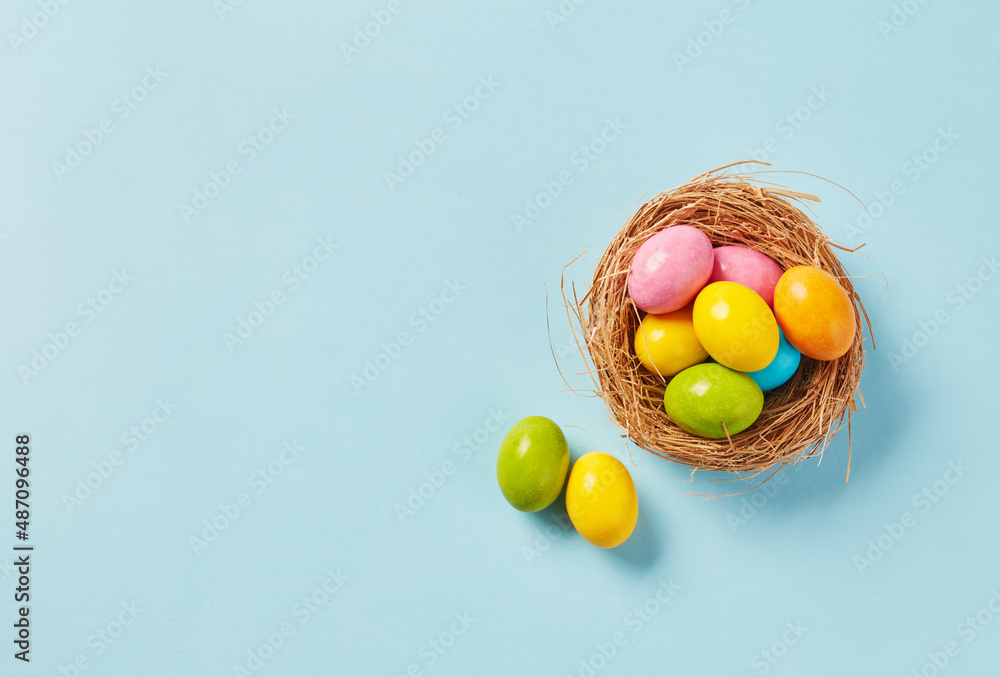 Basket with Colorful Easter Eggs on Blue Background