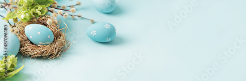 pastel blue easter eggs in bird nest on blue background. copy space for text