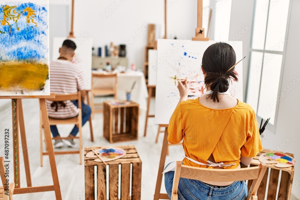 Two hispanic paint students on back view painting at art studio. Two hispanic paint students on back view painting at art studio.