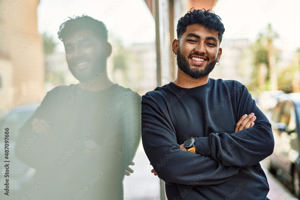 Young arab man smiling confident leaning on the wall at street Young arab man smiling confident leaning on the wall at street
