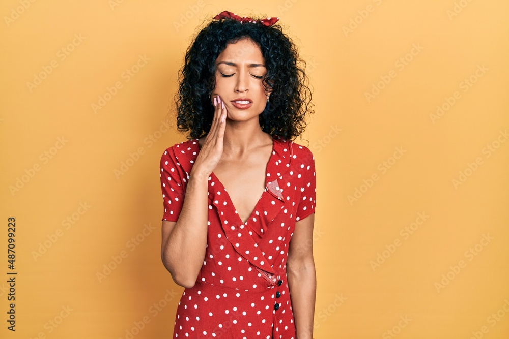 Young latin girl wearing summer dress touching mouth with hand with painful expression because of toothache or dental illness on teeth. dentist Young latin girl wearing summer dress touching mouth with hand with painful expression because of toothache or dental illness on teeth. dentist