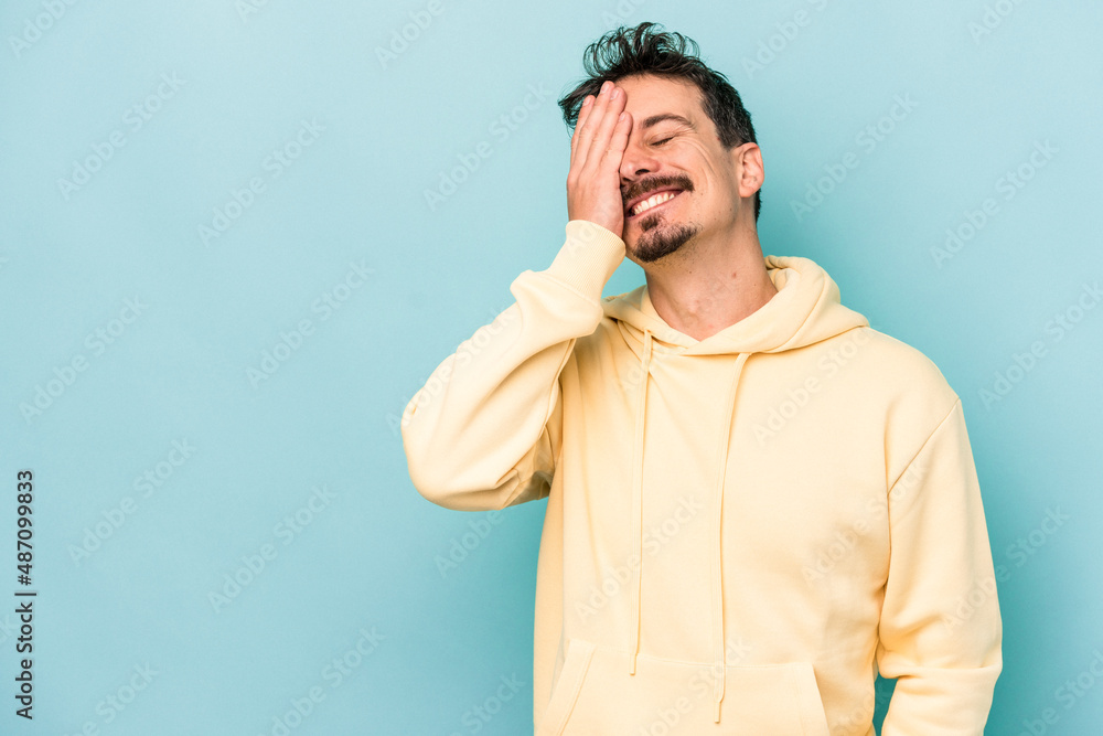 Young caucasian man isolated on blue background laughing happy, carefree, natural emotion. Young caucasian man isolated on blue background laughing happy, carefree, natural emotion.