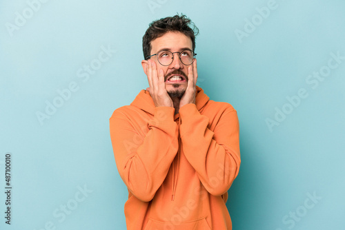 Young caucasian man isolated on blue background whining and crying disconsolately.