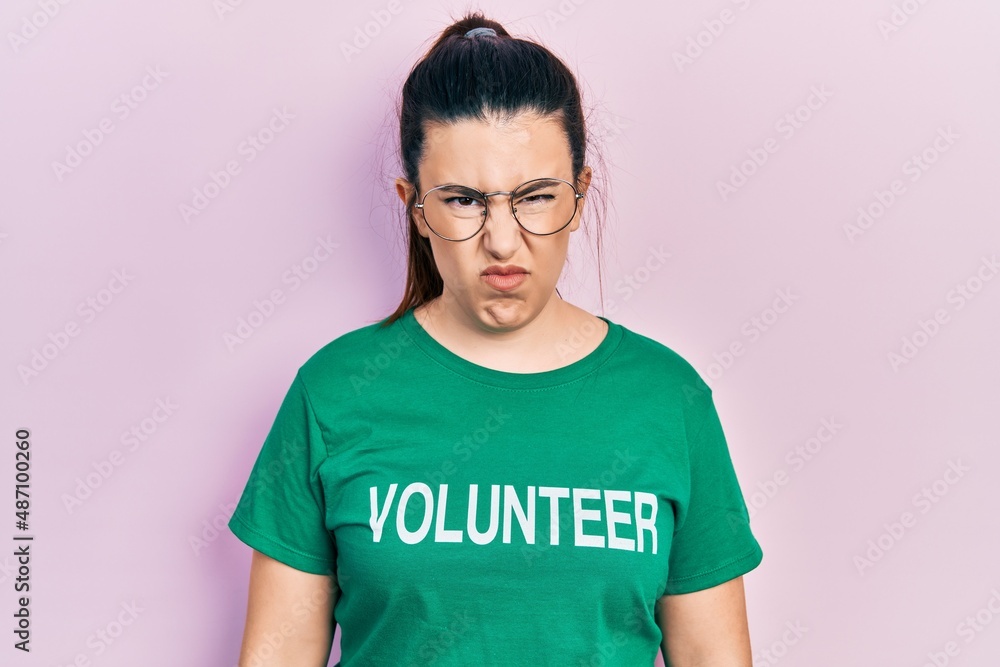 Young hispanic woman wearing volunteer t shirt skeptic and nervous, frowning upset because of problem. negative person. Young hispanic woman wearing volunteer t shirt skeptic and nervous, frowning upset because of problem. negative person.