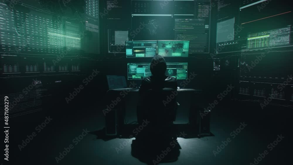 Minimalistic concept shot of alone hacker programmer surrounded by programming codes interface in a dark ambient cyber space, sitting at a table with four monitors doing a hacking attack