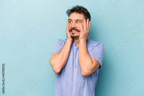 Fotografering Young caucasian man isolated on blue background scared and afraid