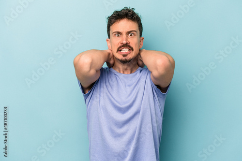 Young caucasian man isolated on blue background screaming with rage.