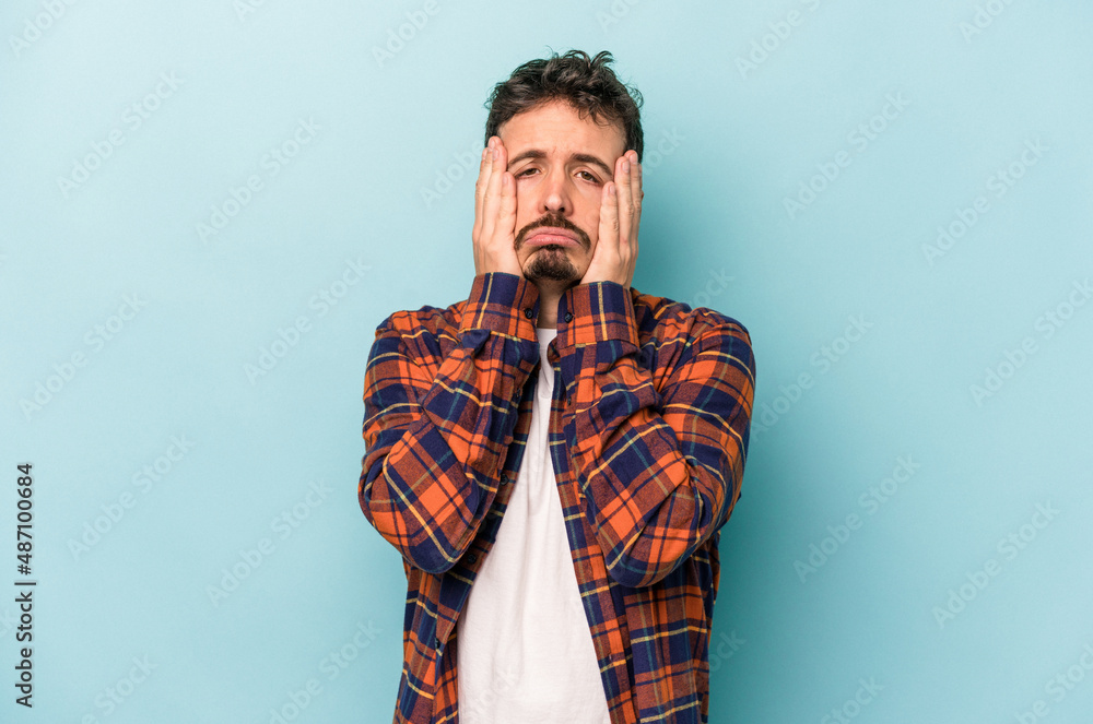 Fototapeta premium Young caucasian man isolated on blue background whining and crying disconsolately.