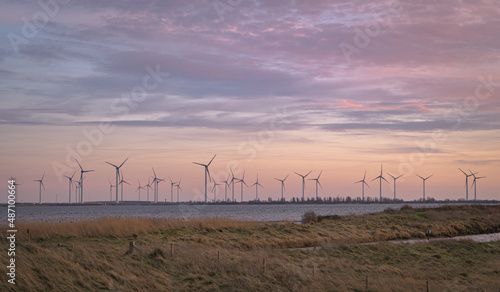 Farma turbin wiatrowych na tle wieczornego kolorowego nieba, czysta energia. photo