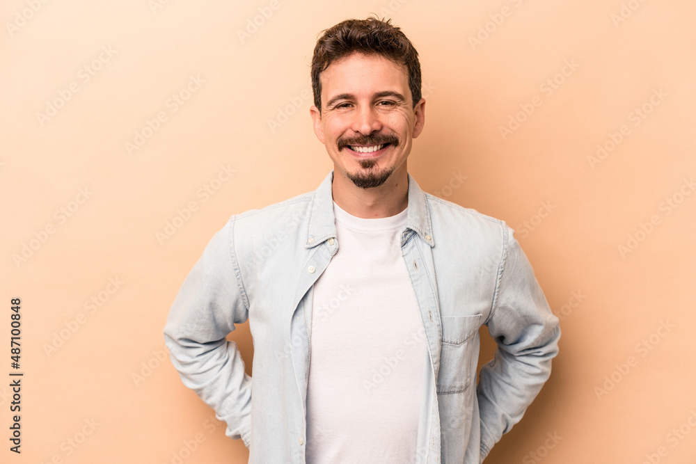 Young caucasian man isolated on beige background happy, smiling and cheerful. Young caucasian man isolated on beige background happy, smiling and cheerful.