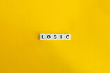 Logic word on letter tiles on bright orange background. Minimal aesthetics.