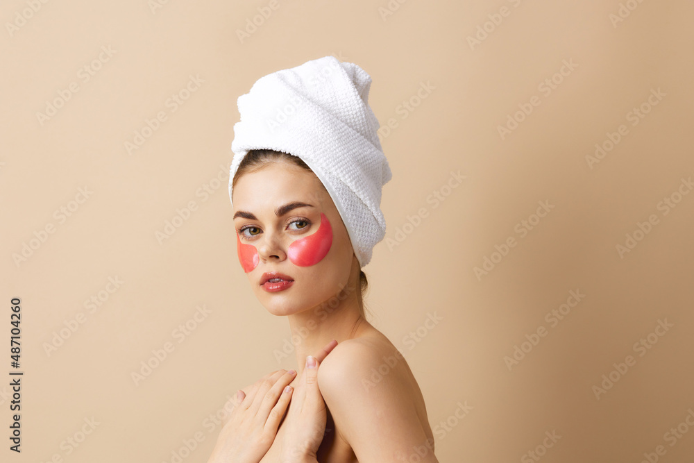 woman skin care face patches bare shoulders beige background woman skin care face patches bare shoulders beige background