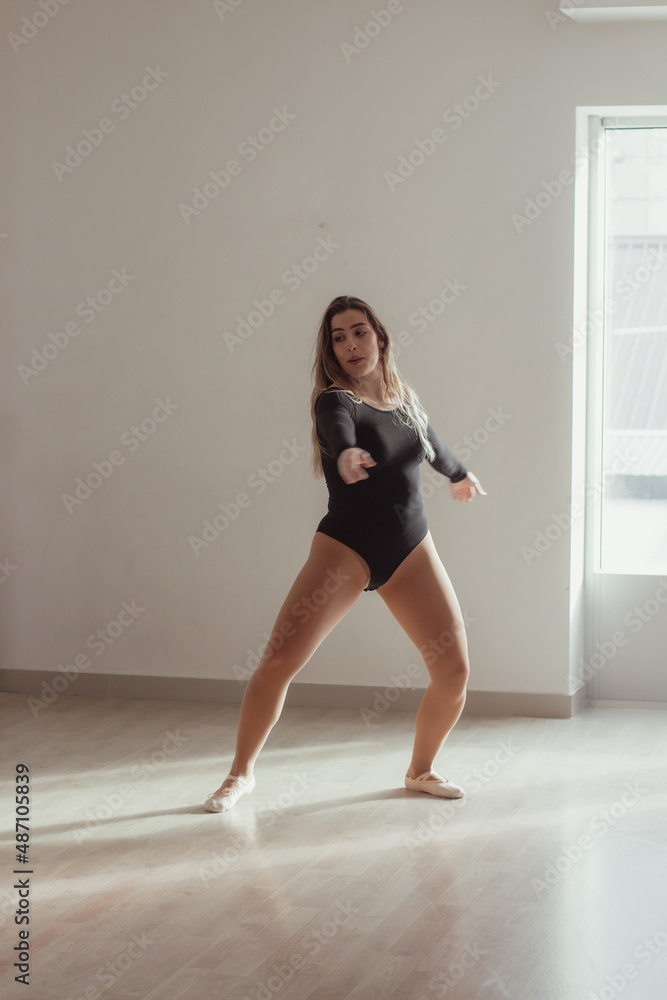 A woman standing in a dance pose in a dance studio, dressed in a dance outfit. A woman standing in a dance pose in a dance studio, dressed in a dance outfit.