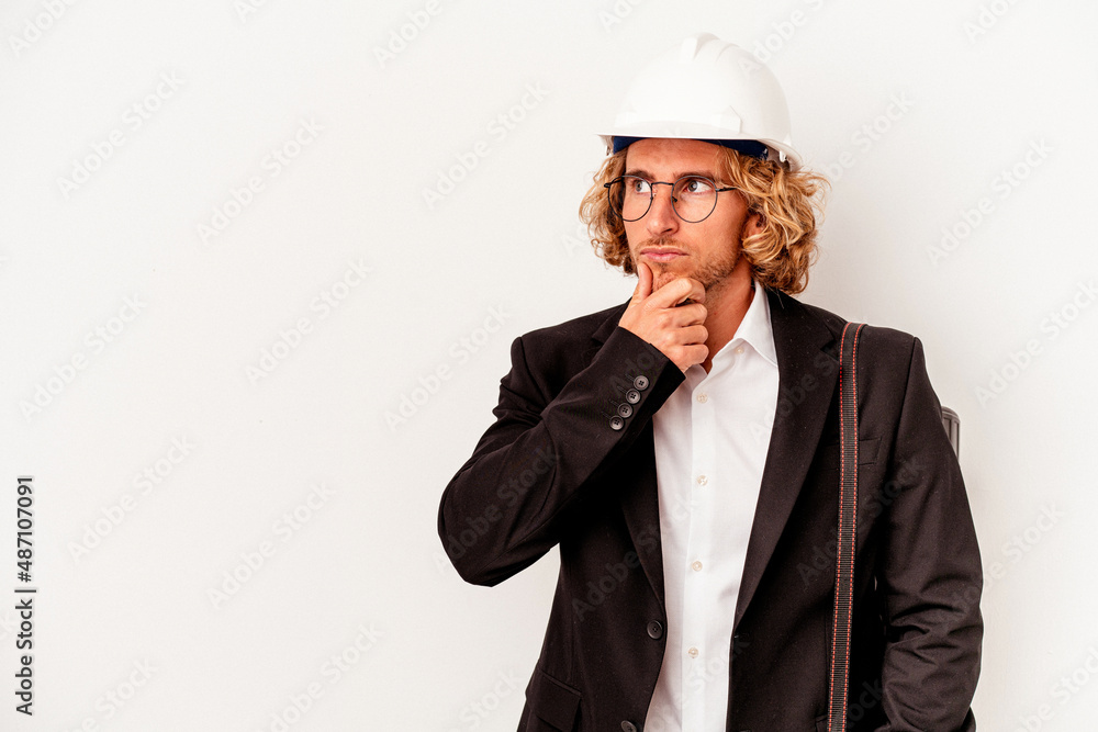 Young architect caucasian man with helmet isolated on white background looking sideways with doubtful and skeptical expression. Young architect caucasian man with helmet isolated on white background looking sideways with doubtful and skeptical expression.