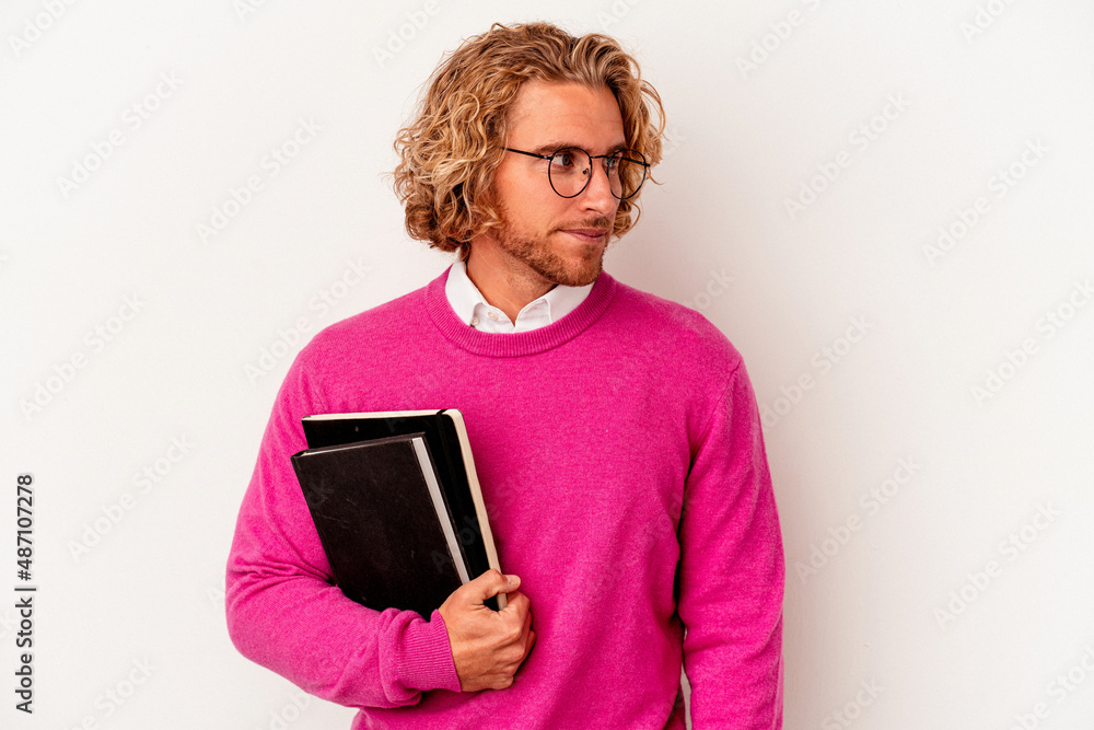 Young student caucasian man isolated on white background looks aside smiling, cheerful and pleasant. Young student caucasian man isolated on white background looks aside smiling, cheerful and pleasant.