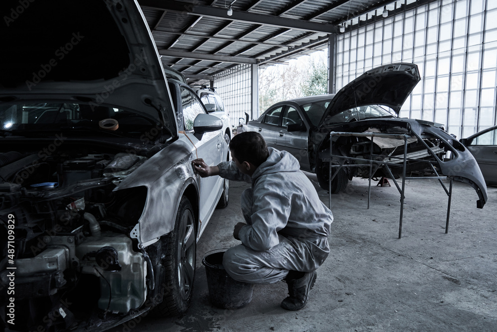 Car service worker repairs restores car Car service worker repairs restores car