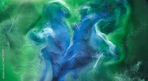 Blue green smoke on black ink background, colorful fog, abstract swirling ocean sea, acrylic paint pigment underwater