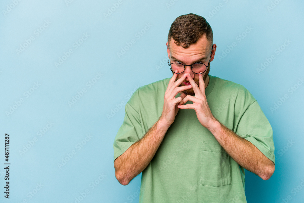 Young caucasian man isolated on blue background making up plan in mind, setting up an idea. Young caucasian man isolated on blue background making up plan in mind, setting up an idea.