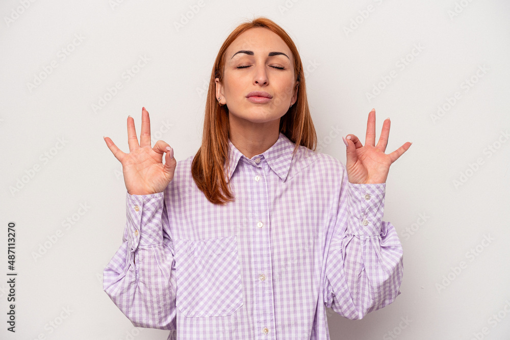 Young caucasian woman isolated on white background relaxes after hard working day, she is performing yoga. Young caucasian woman isolated on white background relaxes after hard working day, she is performing yoga.