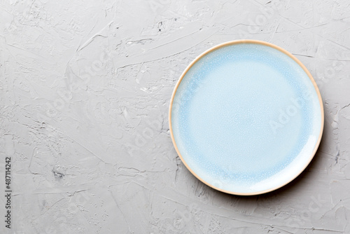 Top view of empty blue plate on cement background. Empty space for your design