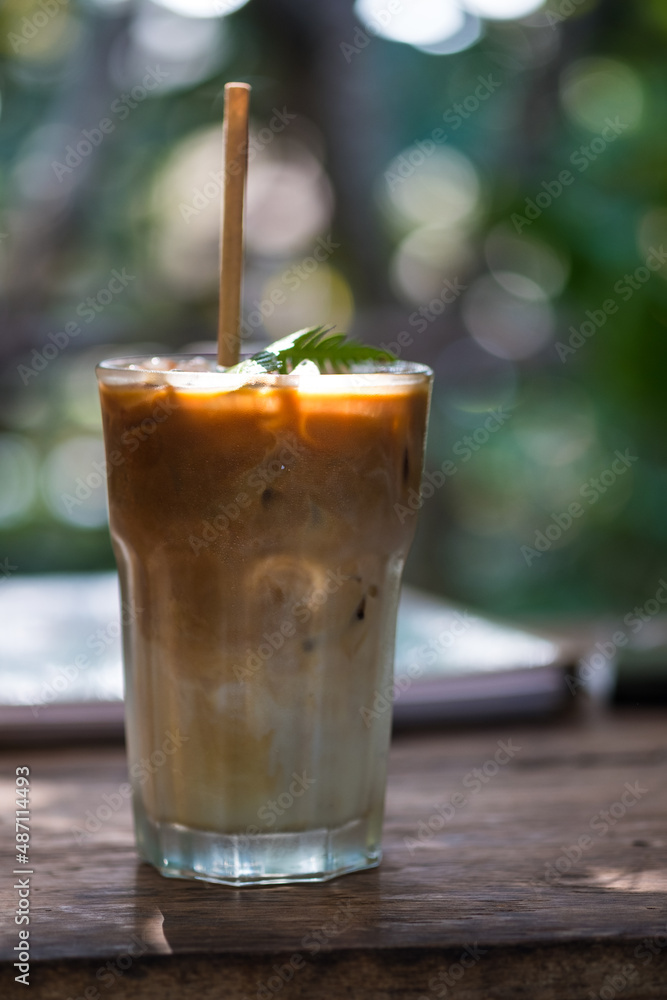 Iced coffee in a tall glass with paper straw Iced coffee in a tall glass with paper straw