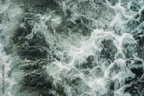 Dark water swirling waves and foam texture background © NadiaA