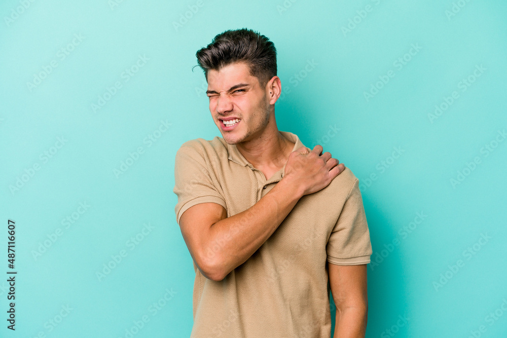 Young caucasian man isolated on blue background having a shoulder pain. Young caucasian man isolated on blue background having a shoulder pain.