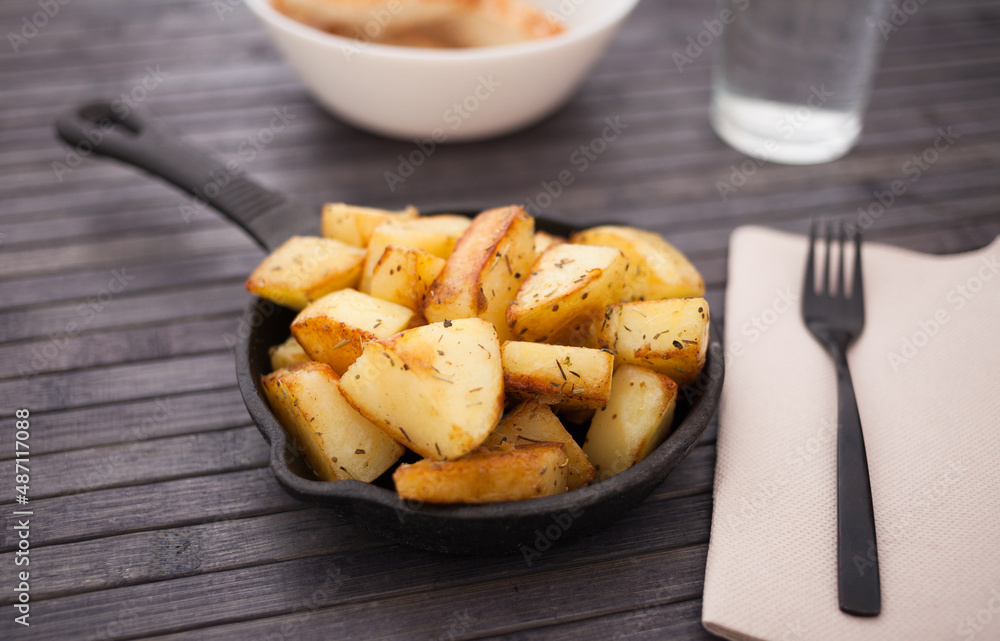 slices of fried potatoes on cast iron snack pan slices of fried potatoes on cast iron snack pan