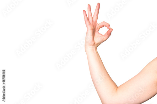 Un brazo de una mujer haciendo el gesto con la mano del número cero. Mano femenina haciendo el símbolo de ok sobre fondo blanco.