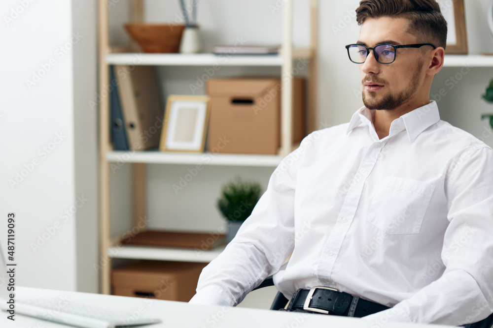 manager wearing glasses sits at a desk office worked office manager wearing glasses sits at a desk office worked office