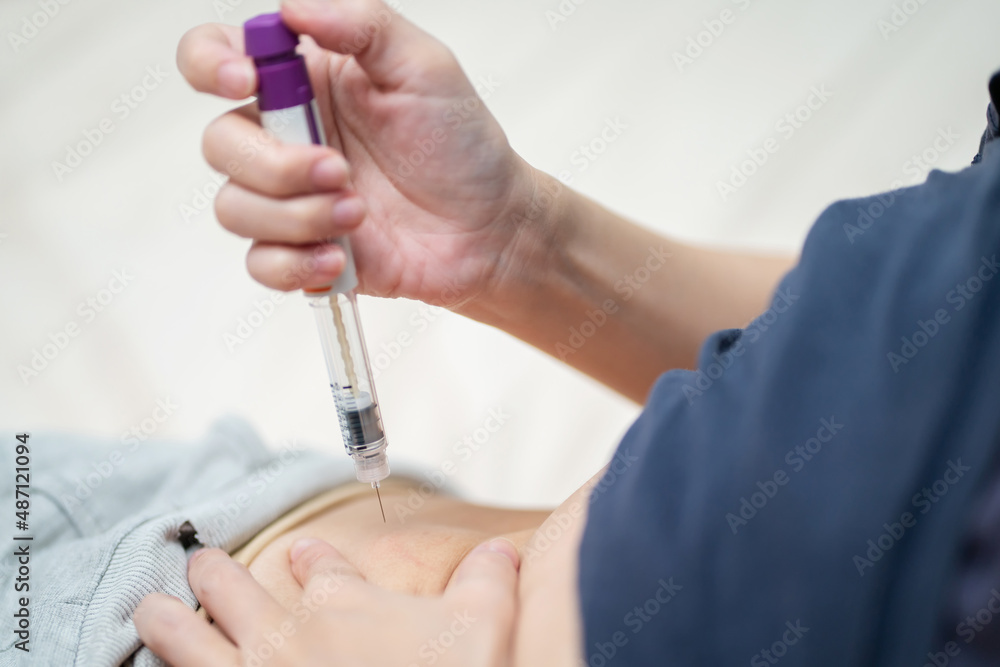 A woman injection hormones at stomach or belly by using syringe pen for increase Ovarian Stimulation. IVF concept. Person in vitro fertilization treatment injection hormone for pregnancy A woman injection hormones at stomach or belly by using syringe pen for increase Ovarian Stimulation. IVF concept. Person in vitro fertilization treatment injection hormone for pregnancy