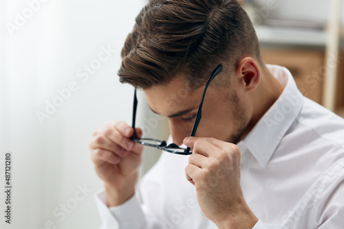 manager wearing glasses sits at a desk office worked technologies