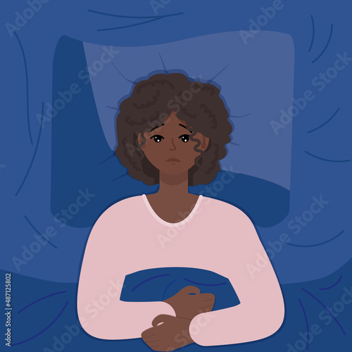 Young dark skinned woman suffering from insomnia in bed, lying in bedroom. Tired person with insomnia. Sleeplessness problem concept.